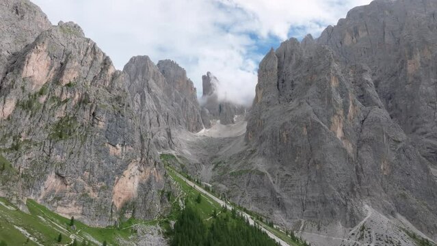Aerial parallax effect view of the Sasmujel limestone mountain near Santa Cristina. The drone is moving backwards revelaing mountains in Valgardena. Dolomites, South Tyrol, Italy. LuPa Creative