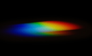 Rainbow reflective colorful sunlight on textured surface of wall. Dispersion and refraction of...
