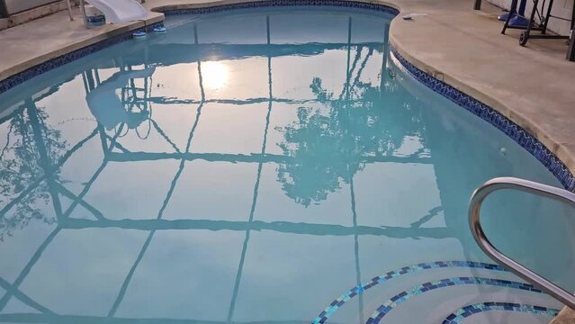 Static view of Florida pool in back yard during sunrise.