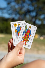 Close-up of a hand with cards from the Spanish deck, with different cards