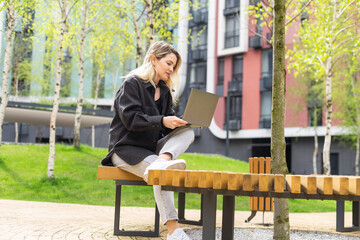 Young woman with laptop outside - 792758301