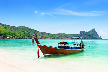 Thai traditional wooden longtail boat and beautiful sand beach at Koh Phi Phi island in Krabi province in Thailand.