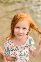 Redhead girl smiling on the beach