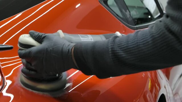 Man Buffing Red Car With Orbital Polisher -. - closeup shot