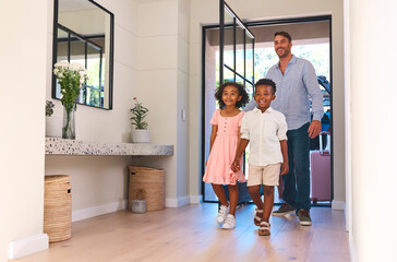 Multi Racial Family With Father And Children Arriving In House Or Apartment For Summer Vacation