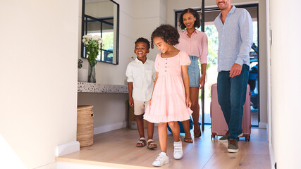 Excited Multi Racial Family With Luggage Arriving In House Or Apartment For Summer Vacation