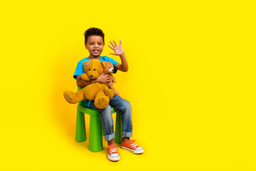 Full body photo of multiethnic multinational child dressed blue t-shirt hold teddy bears waving...