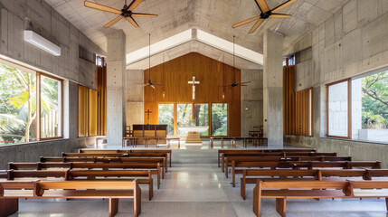 Small Catholic chapel with wooden pews facing small altar. Faith, a place for prayer, a meeting of church parishioners.