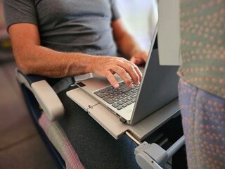 Man Working on Laptop Computer on Train
