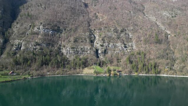 Drone clip showing fresh green glacial lake water, surrounded by steep alpine mountains