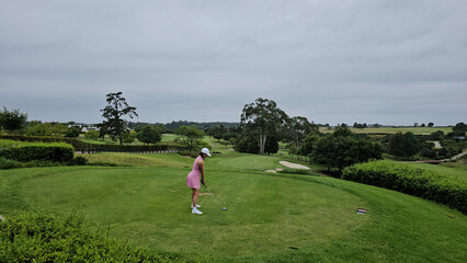 Woman in a Pink Dress Playing Golf