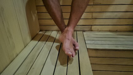 Person Standing on Wooden Floor in Sauna