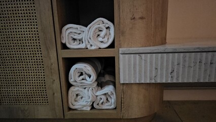 Neatly Stacked White Towels in Cabinet