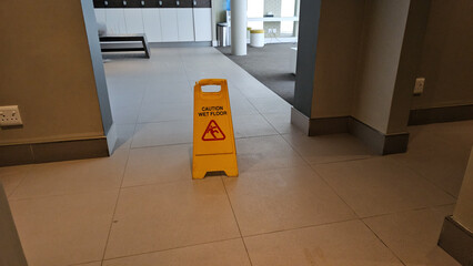 Yellow Caution Sign in Middle of Hallway