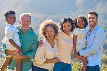 Portrait Of Three Generation Family Laughing And Smiling Standing Outdoors In Countryside