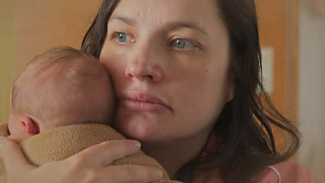 Tierd Mother Rests Tenderly Holding Newborn Baby for the First Time in Hospital, Portrait