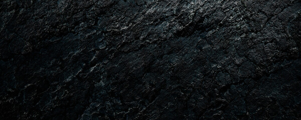 Black stone background with spotlight. Rough rock surface texture material.