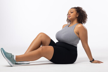 Biracial plus size model poses on white background