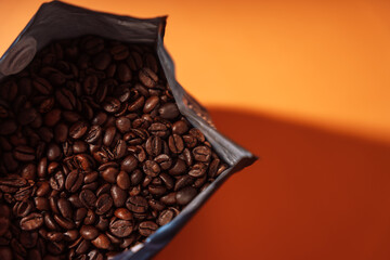 Zip bag with coffee beans close-up on an orange background.