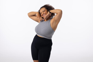 Biracial plus size young female model poses, hands on head, smiling, white background, copy space - 792789717
