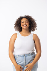 Biracial young female plus size model stands with hands on hips, white background - 792789793
