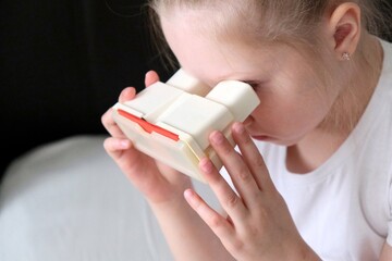 A child is watching slides through a slide show. Retro, slides. Old plastic stereoscope with stereo...