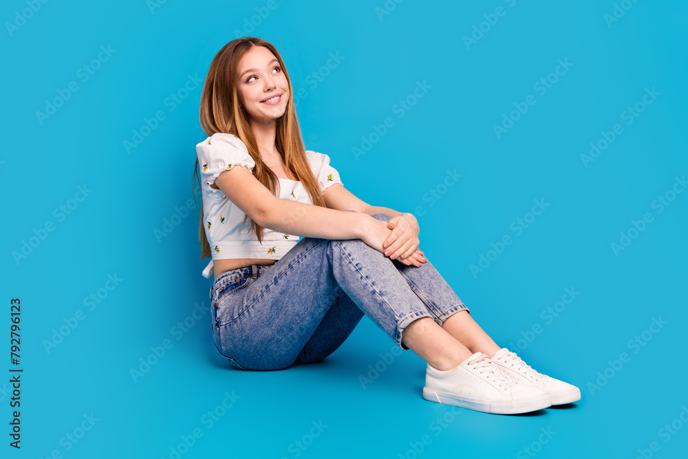 Poster Full length portrait of lovely girl look empty space imagine wear top isolated on blue color background