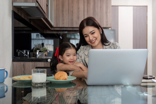 Working mom work from home office. businesswoman and cute child using laptop work freelancer workplace in home, Lifestyle family moment