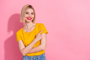 Photo of adorable shiny lady dressed yellow t-shirt showing finger empty space isolated pink color...