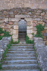 Stone stairs to vertical Mudejar arch to access a fortress
