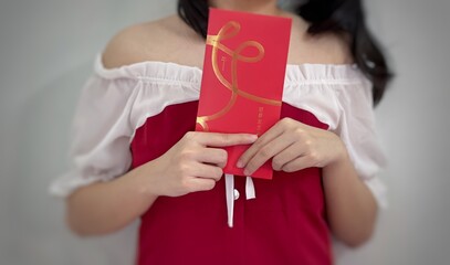 A girl holding a red packet. A Chinese girl holding a red envelope angpao during Chinese New Year.
