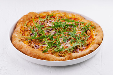 Fresh tuna and arugula pizza on white plate