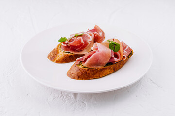Elegant prosciutto bruschetta on white plate
