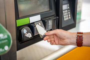 Close up view of man hand pays for fuel with a credit card on terminal of self-service filling...