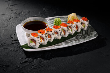 Elegant sushi roll platter with caviar and soy sauce