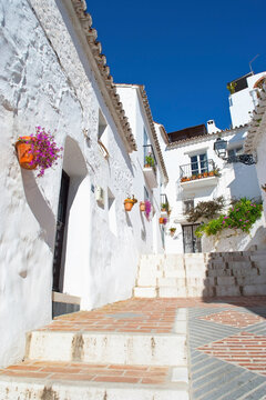 A captivating image of a traditional Spanish street adorned with bright flowers and white-washed walls, reflecting the cultural heritage and beauty