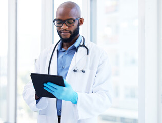 Healthcare, tablet and black man doctor at hospital for research, planning or schedule. Help,...