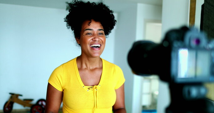 One young black woman speaking in front of camera giving testimony for online channel. 20s female vlogger creating video post engaged with new media