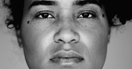 Monochrome portrait of a Solemn Young Black Woman Staring Intently at Camera, Macro Close-Up of Serious Facial Expression, 20s African Descent Female, black and white