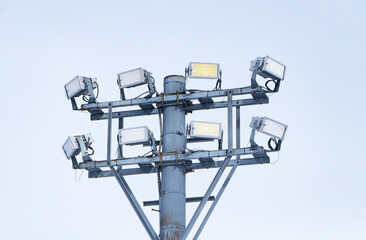 Large spotlight pole dark cloudy sky is background. It is technology that provides light in wide...