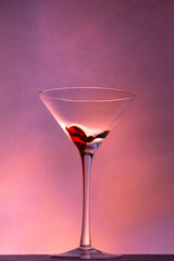 Martini glass on a beautiful long stem with a red accent on a beautiful colorful background