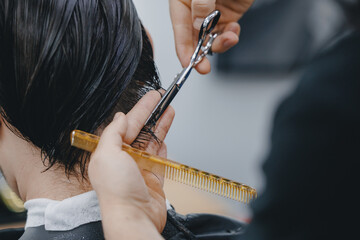 Concept Barbershop for man. Closeup master hairdresser does hairstyle and style with scissors and...