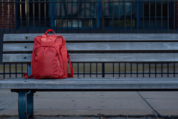  solitary backpack left on a school bench