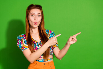 Photo portrait of attractive young woman point shocked empty space dressed stylish retro clothes isolated on green color background