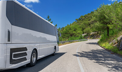 A white bus is descending through a cloudcovered ecoregion, surrounded by lush trees and plants on...