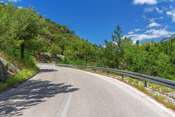 Country road with rocky mountains in the background.