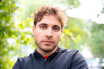 close-up serious sporty man looking at camera outdoors.