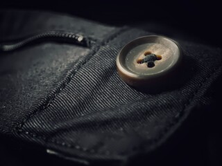 Close-up of a vintage button in a denim jeans back pocket.