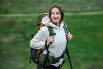 Successful hiker hiking on seaside mountain peak. Young beautiful female backpacker traveling alone. Attractive girl traveler during holiday vacation trip.