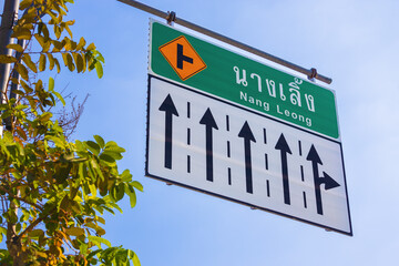 Road information sign with directional arrows against blue sky at Bangkok, Thailand. Nang Leong...